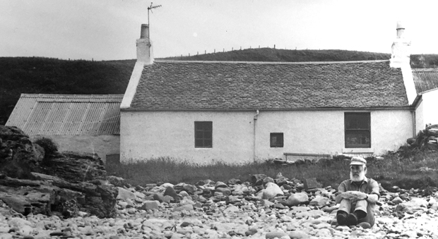 Bill Wright on the shore outside his Kintyre cottage, Bellochantuy. Kintyre-cottage-w